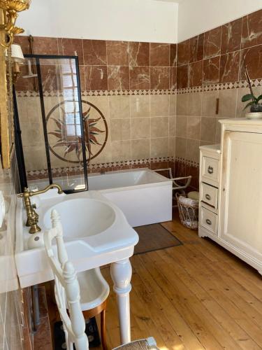 a bathroom with a tub and a sink and a mirror at Domaine Les Bruyères in Autry-le-Châtel