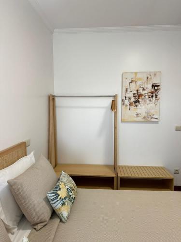 a bedroom with a bed with a bench and a painting at Guest House MJ in Póvoa de Varzim