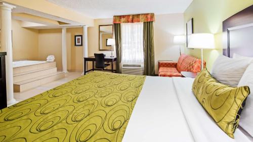 a hotel room with a bed and a bathroom at Best Western Plus Addison/Dallas Hotel in Addison