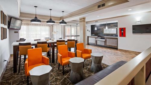 an office lobby with a bar with orange chairs at Best Western Plus Addison/Dallas Hotel in Addison
