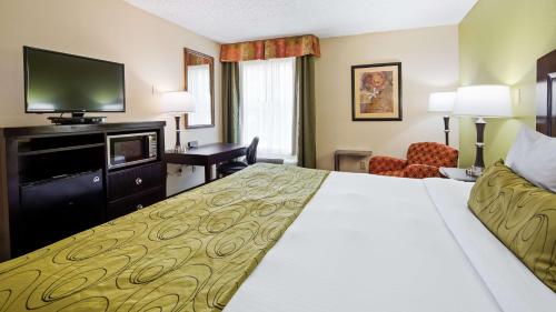 a hotel room with a bed and a flat screen tv at Best Western Plus Addison/Dallas Hotel in Addison