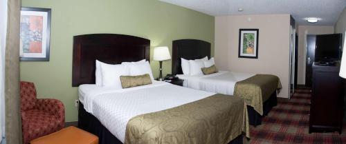 a hotel room with two beds and a chair at Best Western Plus Addison/Dallas Hotel in Addison