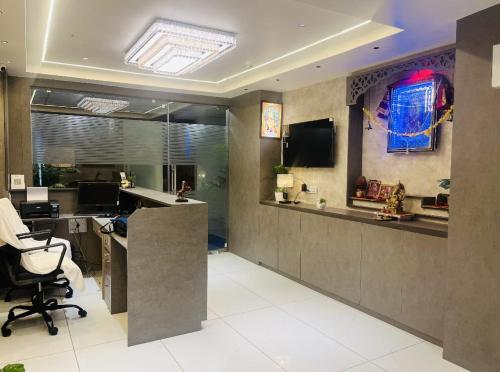an office with a desk and a monitor on the wall at Hotel Royal Square in Gandhinagar