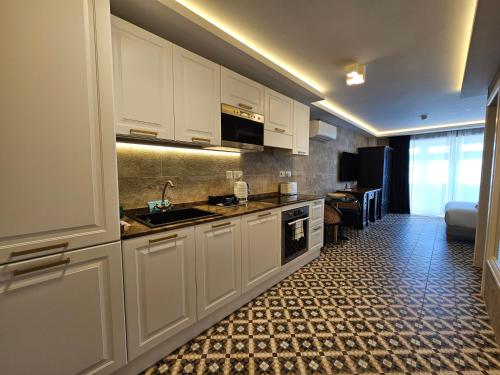 a kitchen with white cabinets and a sink at Balcony Hotel in St Julian's