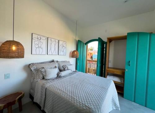 a bedroom with a bed and a green door at Flô Casa Hotel in Trancoso