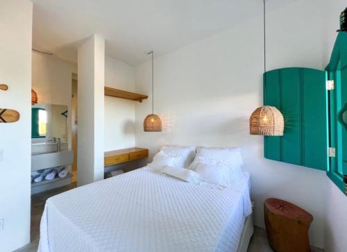 a bedroom with a white bed with two pillows at Flô Casa Hotel in Trancoso