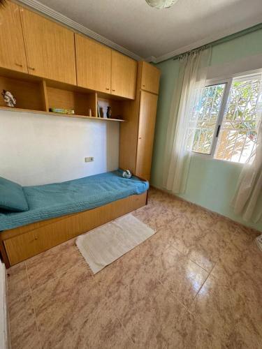 a small bedroom with a bed and a window at Casa Jardín SevillaMia in Orihuela Costa in Orihuela Costa