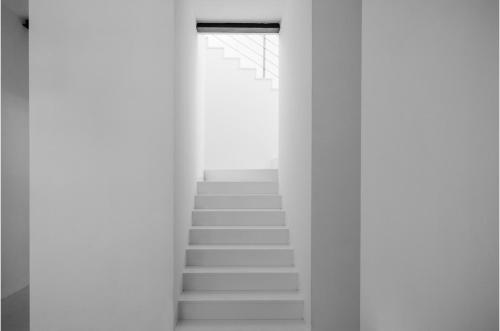 a stairway with white walls and white stairs at Vittoria Design Hotel di Luce Hotels in Siena