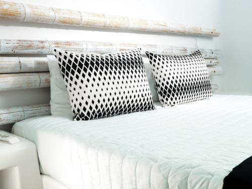 a white bed with two pillows on top of it at San Marino Suites by Calm Collection in Fira