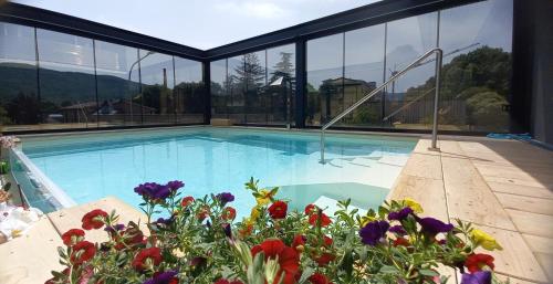 a large swimming pool with flowers in the foreground at Hotel Giardino in Bibbiena