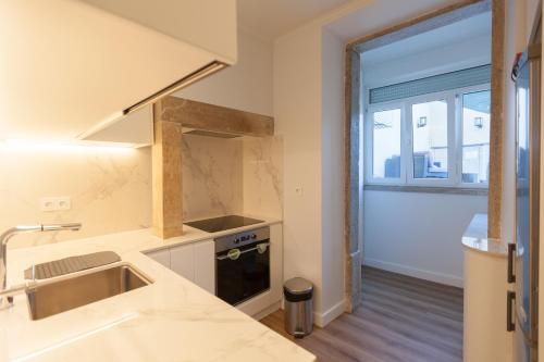 a kitchen with a sink and a window at FLH Graça Charming Duplex with Small Pool in Lisbon