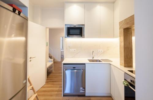 a small kitchen with white cabinets and a sink at FLH Graça Charming Duplex with Small Pool in Lisbon