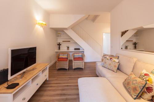 a living room with a couch and a tv at FLH Graça Charming Duplex with Small Pool in Lisbon