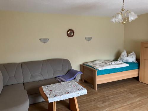 a living room with a couch and a bed at Landhof Lindner in Lüptitz