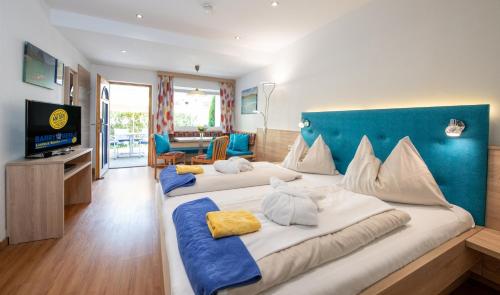 a hotel room with two beds and a television at Barry Memle Directly at the Lake in Velden am Wörthersee