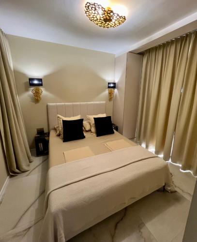 a bedroom with a large bed with curtains and a chandelier at LIZA I Sea View in Lokva Rogoznica
