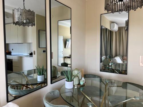 a dining room with a glass table and mirrors at LIZA I Sea View in Lokva Rogoznica
