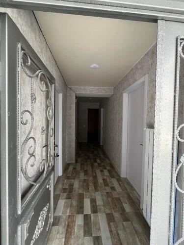 an empty hallway with a door and a tile floor at მაკას სასტუმრო in Chiatʼura