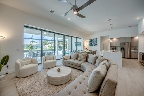 a living room with a large couch and a table at BRANDNEW Villa-PureSun at Canal intersection, heated saltwater pool and spa, facing south in Cape Coral