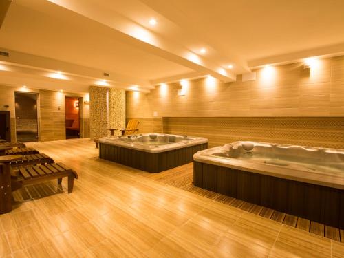 a large bathroom with two tubs in a room at Park Hotel Asenevtsi in Veliko Tŭrnovo
