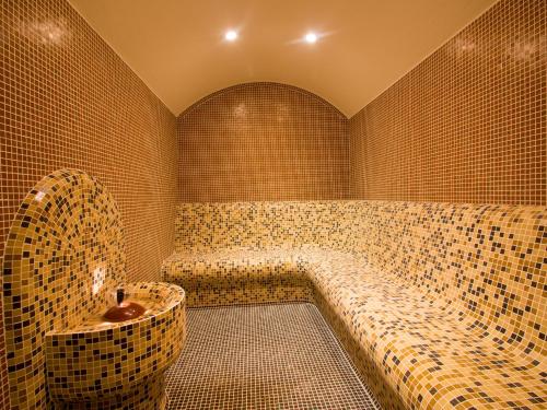 Park Hotel Asenevtsi في فيليكو ترنوفو: غرفة حمام مع حوض في غرفة من البلاط