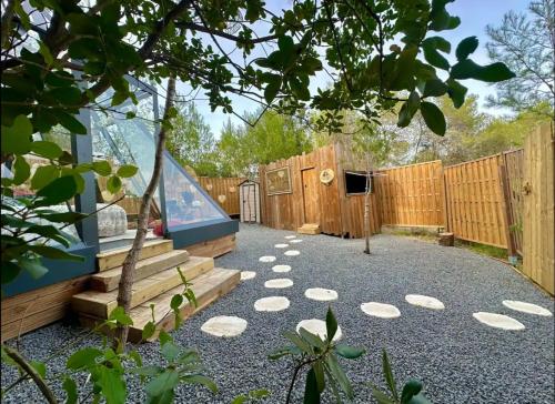 a backyard with a fence and a bench and a table at Magnifique Pyramide en Verre in Montarnaud