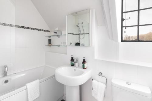 a white bathroom with a sink and a toilet at voco Oxford Thames by IHG in Oxford