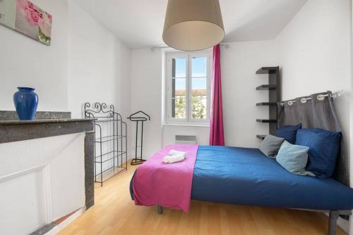 - une chambre avec un lit bleu et une couverture rose dans l'établissement Aurore - T1 21, à Carcassonne