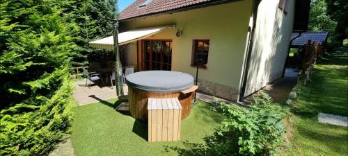 a wooden stool in the yard of a house at Elitní wellness penzion U Dvou jedlí v srdci Českého ráje in Turnov