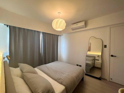a bedroom with a bed and a large mirror at Modern Nordic 1 Bedroom Condo near Eastwood, Quezon City in Manila