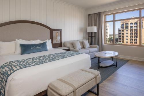 a hotel room with a large bed and a chair at Sandpearl Resort Private Beach in Clearwater Beach