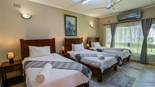 Кровать или кровати в номере Zambezi Family Lodge - Rhino Room