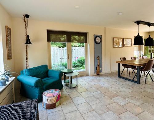 ein Wohnzimmer mit einem blauen Sofa und einem Tisch in der Unterkunft - Tulipa - Vakantiehuis nabij de bloembollenvelden, het meer en strand in Noordwijkerhout