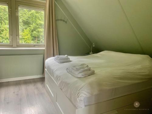 ein Schlafzimmer mit einem Bett mit Handtüchern darauf in der Unterkunft - Tulipa - Vakantiehuis nabij de bloembollenvelden, het meer en strand in Noordwijkerhout
