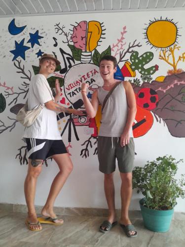 two men standing in front of a wall with a mural at Hostal Makesa Tatacoa in Villavieja