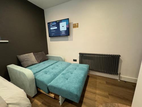 a room with a bed and a tv on the wall at Southgate Luxury Apartments-Jaquzzi Bath-Private Parking- 2 Min M62 in Elland