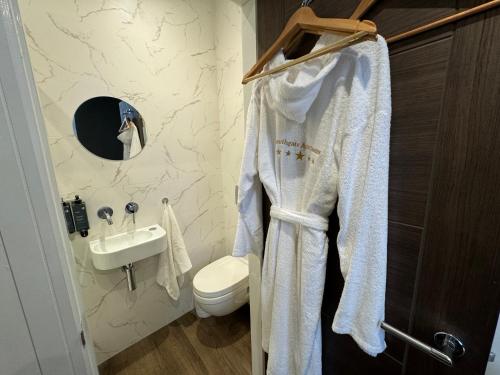 a bathroom with a white robe hanging on a rack at Southgate Luxury Apartments-Jaquzzi Bath-Private Parking- 2 Min M62 in Elland