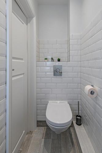 a bathroom with a white toilet and a toilet paper roll at Riverside 1 BD Central Apartment by Hostlovers in Kaunas