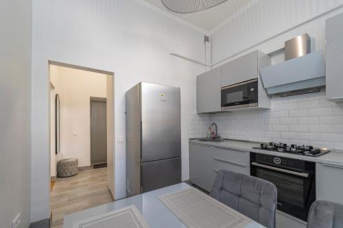 a kitchen with a stainless steel refrigerator and a table at Riverside 1 BD Central Apartment by Hostlovers in Kaunas