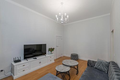 a living room with a couch and a flat screen tv at Riverside 1 BD Central Apartment by Hostlovers in Kaunas
