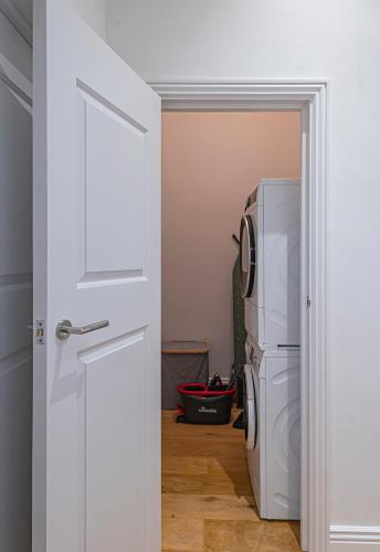 a kitchen with a washer and dryer next to a door at Riverside 1 BD Central Apartment by Hostlovers in Kaunas