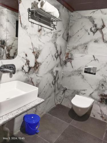 a marble bathroom with a sink and a toilet at MOMENTS RESORT in Rānchī