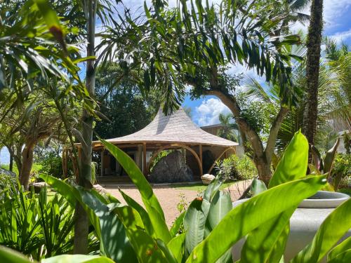 a gazebo in a garden with palm trees at Cape Pakarang Wow Wild Wellness Escapes in Khao Lak