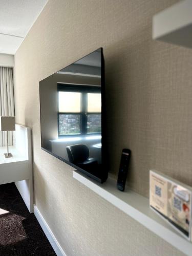 a mirror on a wall with a chair in a room at Van Der Valk Hotel Rotterdam Nieuwerkerk in Nieuwerkerk aan den IJssel