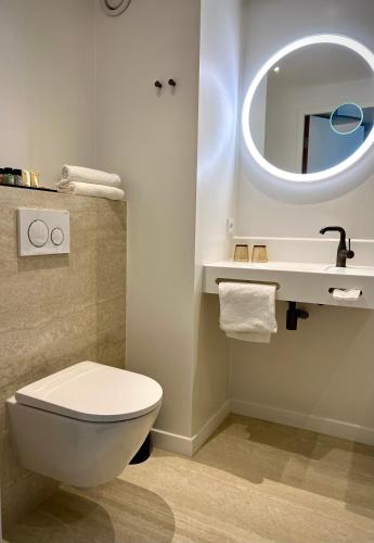 a bathroom with a toilet and a sink and a mirror at Van Der Valk Hotel Rotterdam Nieuwerkerk in Nieuwerkerk aan den IJssel