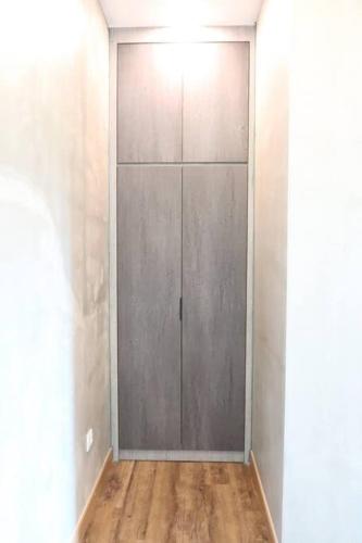 a metal door in a room with a wooden floor at U House Exclusive Retreat in Alor Gajah in Kampong Alor Gajah