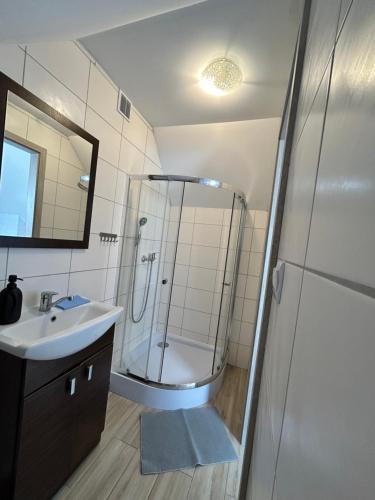 a bathroom with a shower and a sink at Dom Gościnny Stokrotka in Pustkowo