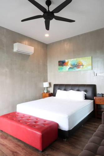 a bedroom with a white bed and a red bench at U House Exclusive Retreat in Alor Gajah in Kampong Alor Gajah