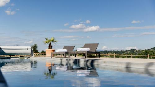 two chairs sitting next to a swimming pool at ÉCURIE DES 2 TOURS in Torchefelon