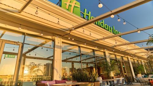 a store front with tables and chairs and windows at Holiday Inn Tashkent City by IHG in Tashkent